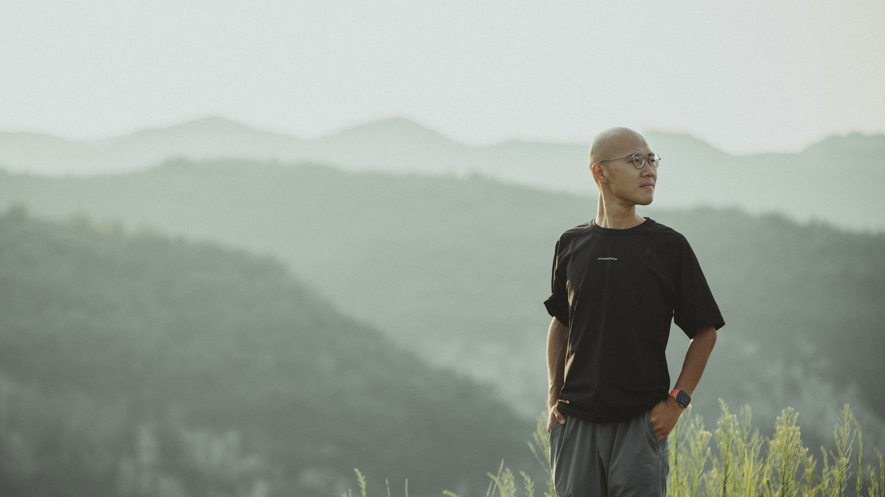 Sieh standing before a sunlit mountain landscape