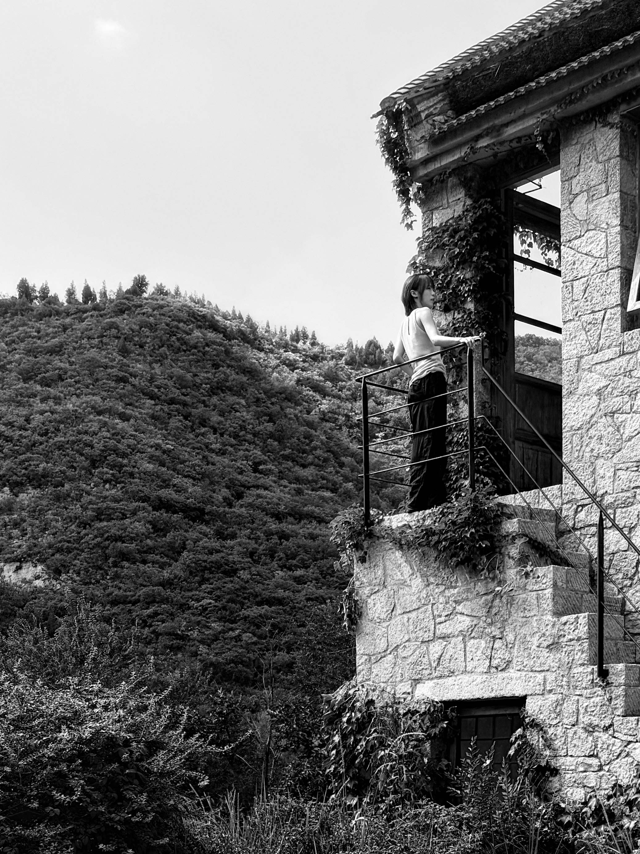 Woman standing on a stone house balcony in Zibo